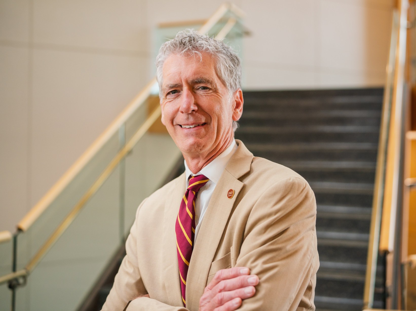 Charles Nies stands in the Kathryn A. Martin Library in front of stairs.