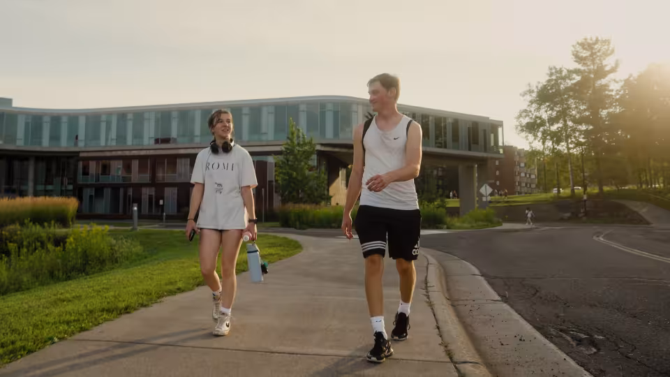 two UMD students in workout wear walking on campus